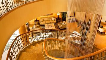 A spiral staircase with a curved railing, a sofa set, and a coffee table in the lower level.