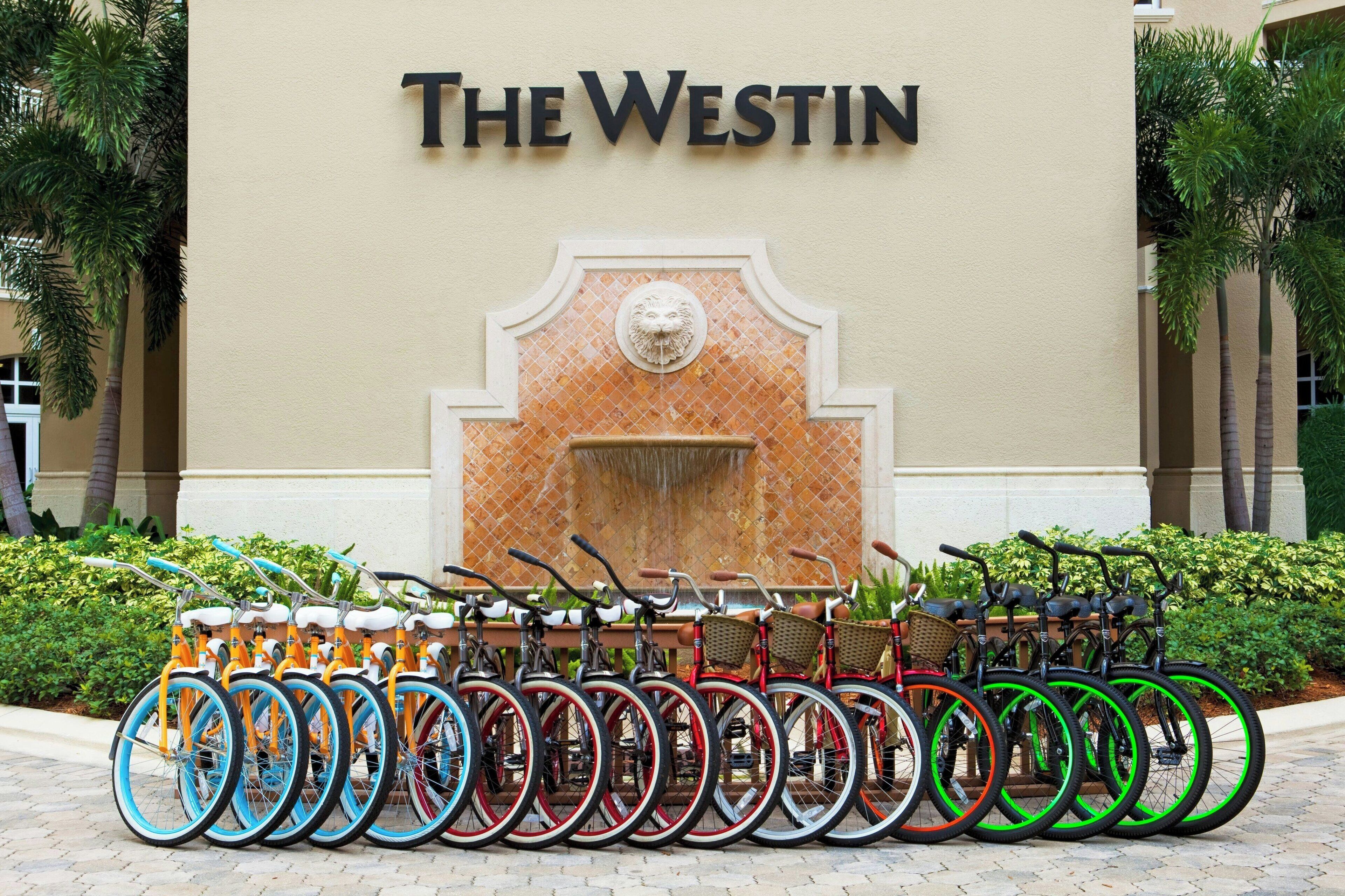 A row of bicycles parked in front of a building with a sign reading "The Westin".