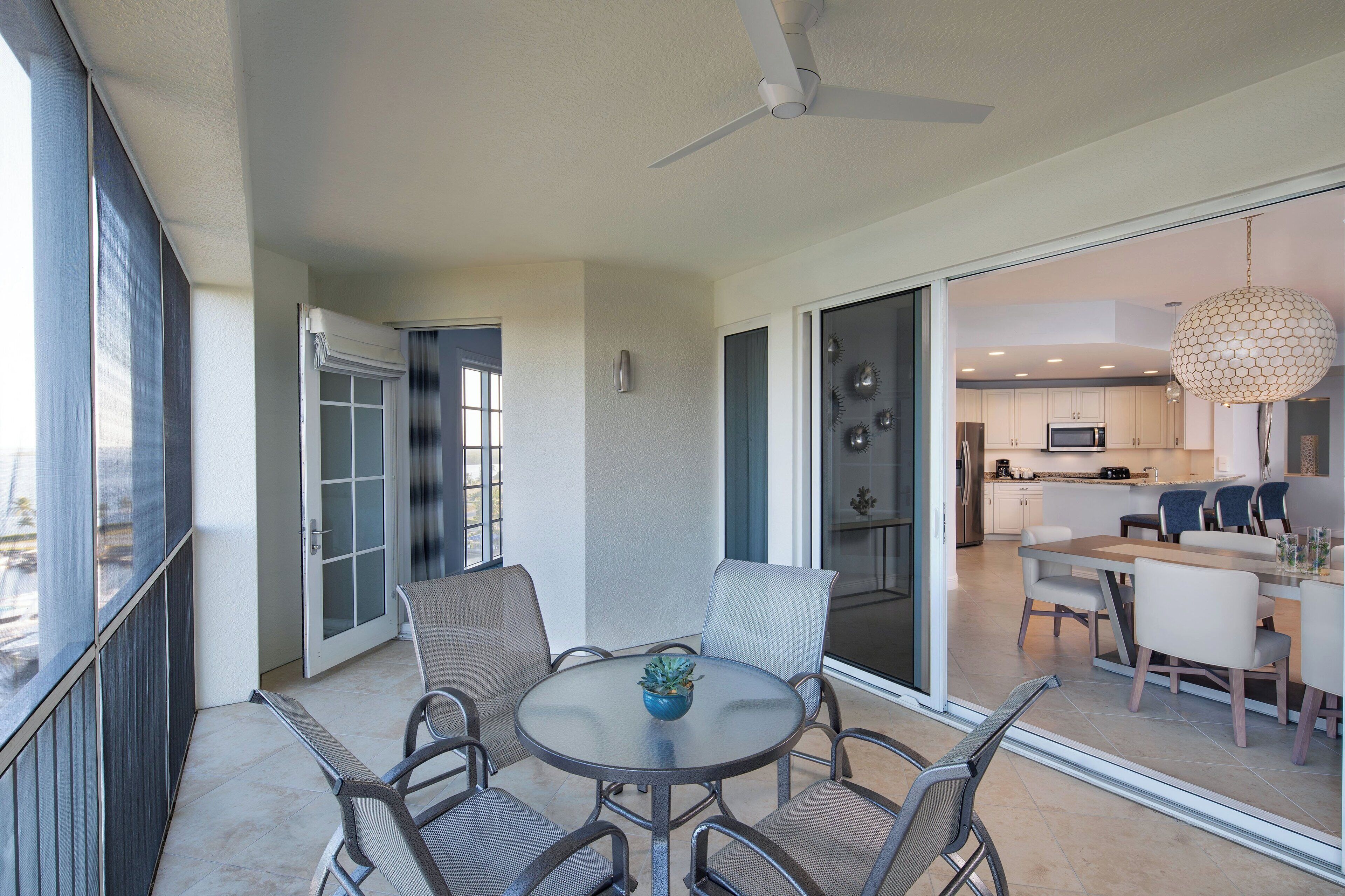 Un espace repas moderne avec une table ronde, des chaises et un ventilateur de plafond.