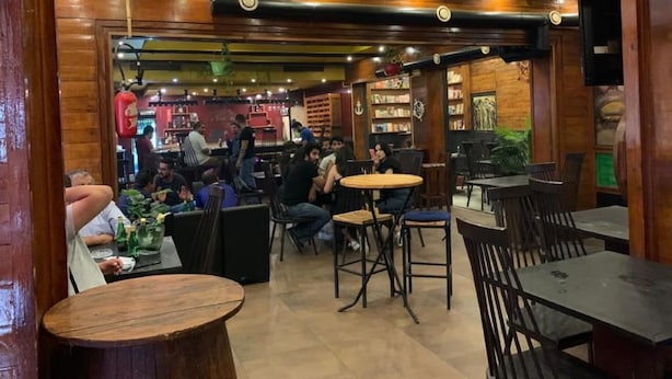 An indoor restaurant with wooden walls and ceiling, tables and chairs, and a bar area. - Tunisie Confort (Tunis)