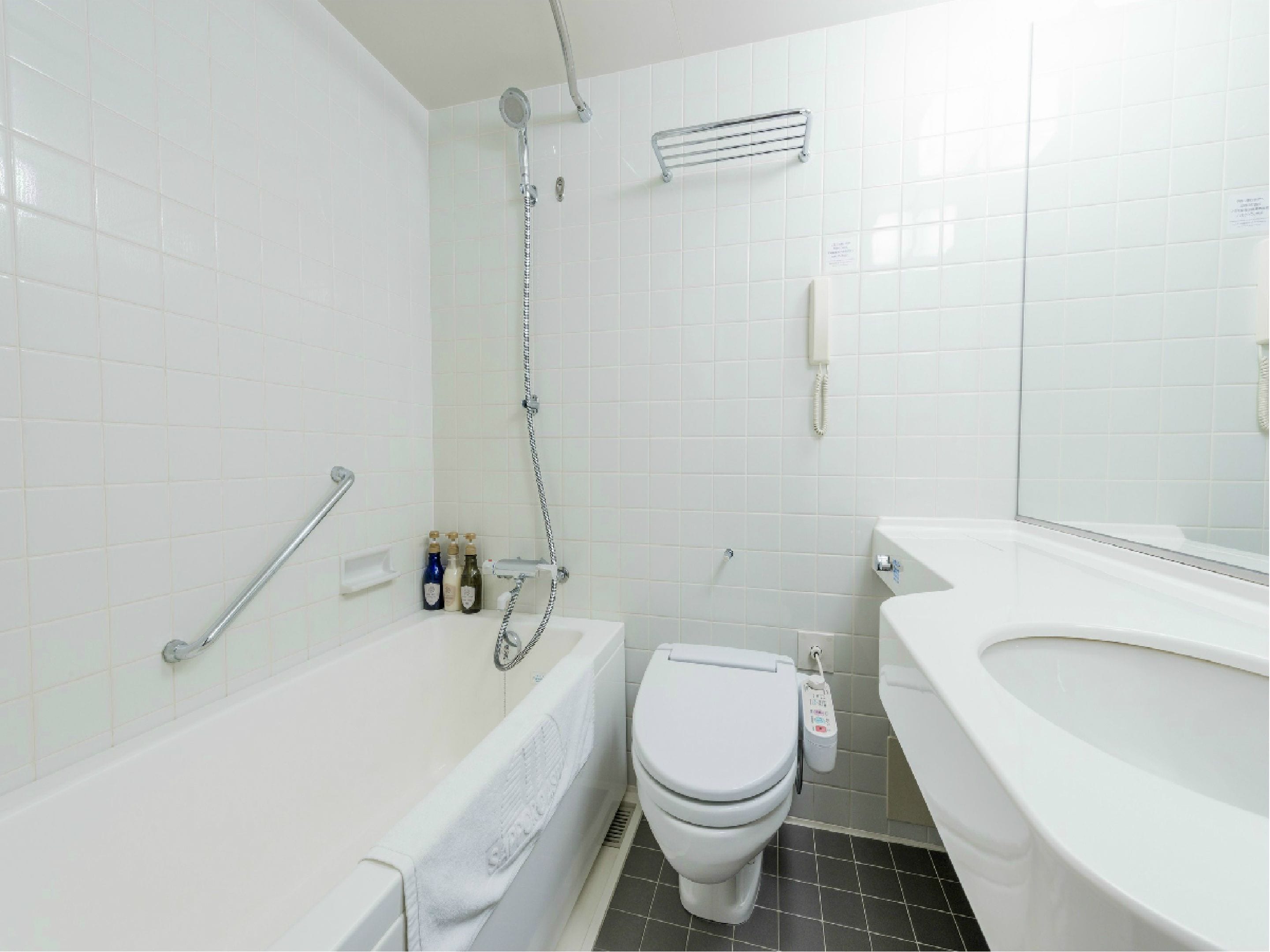 A modern bathroom with a bathtub, toilet, and a shower.