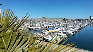 A marina with numerous boats docked, a clear blue sky, and a building in the background. - LOGIS La Régence (Cherbourg-en-Cotentin)