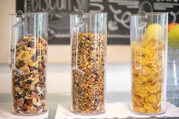 Tres recipientes de vidrio con distintos tipos de cereales y frutas secas.