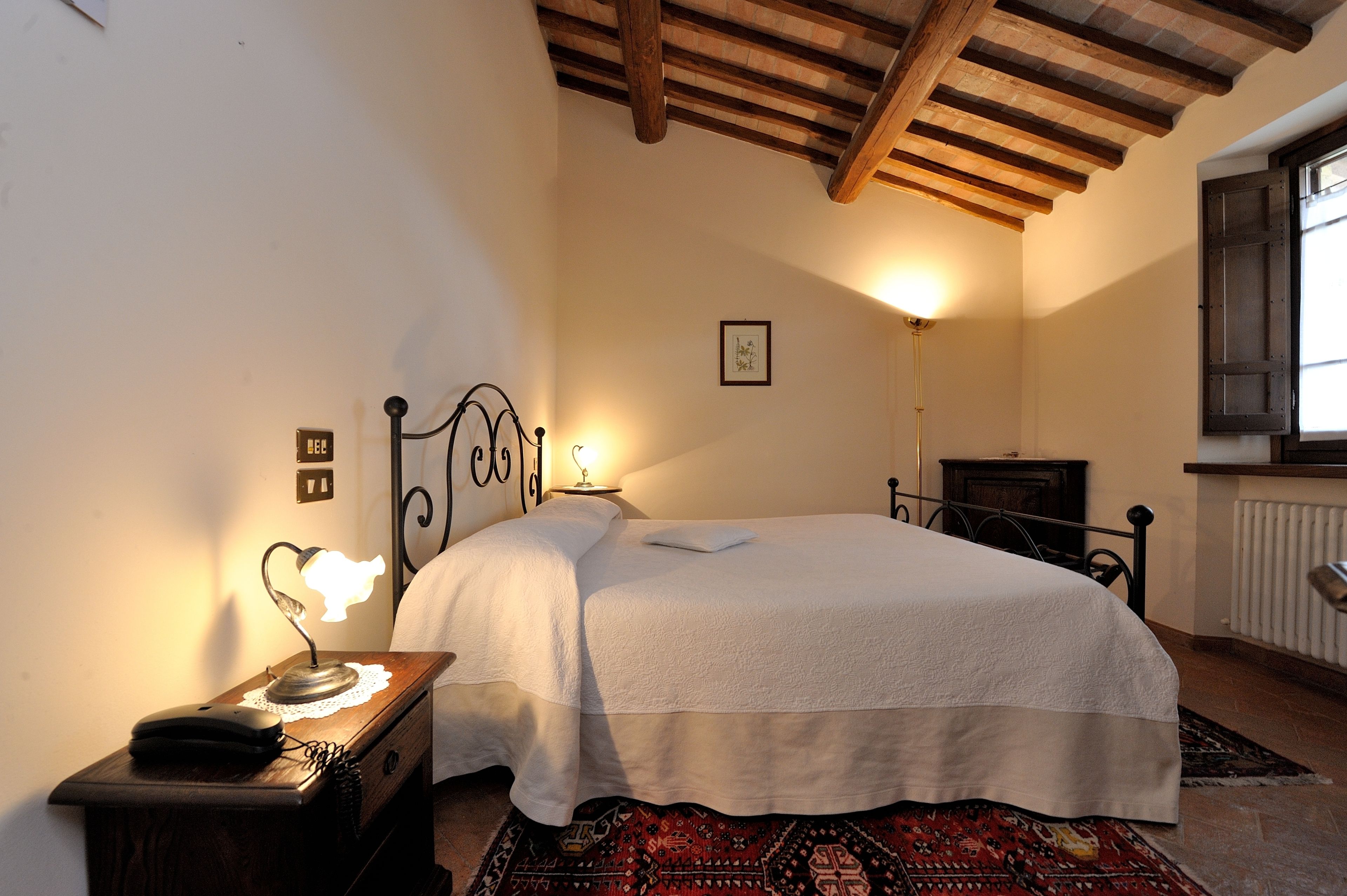 Una camera da letto con un letto, una lampada da comodino e un tavolino.