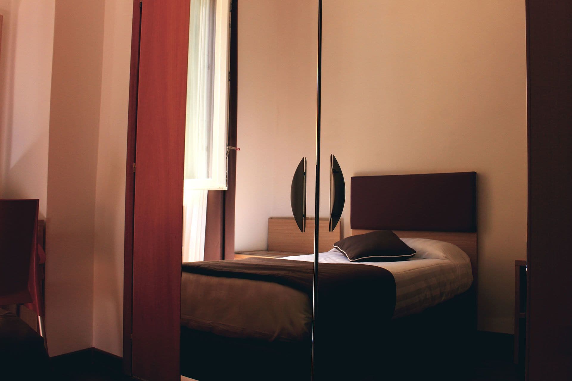 Una camera da letto con un letto, un comodino e una finestra.
