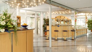 Eine moderne Bar mit einer polierten Granit-Arbeitsplatte, mehreren Barhocker und einer Auswahl an Flaschen und Gläsern.