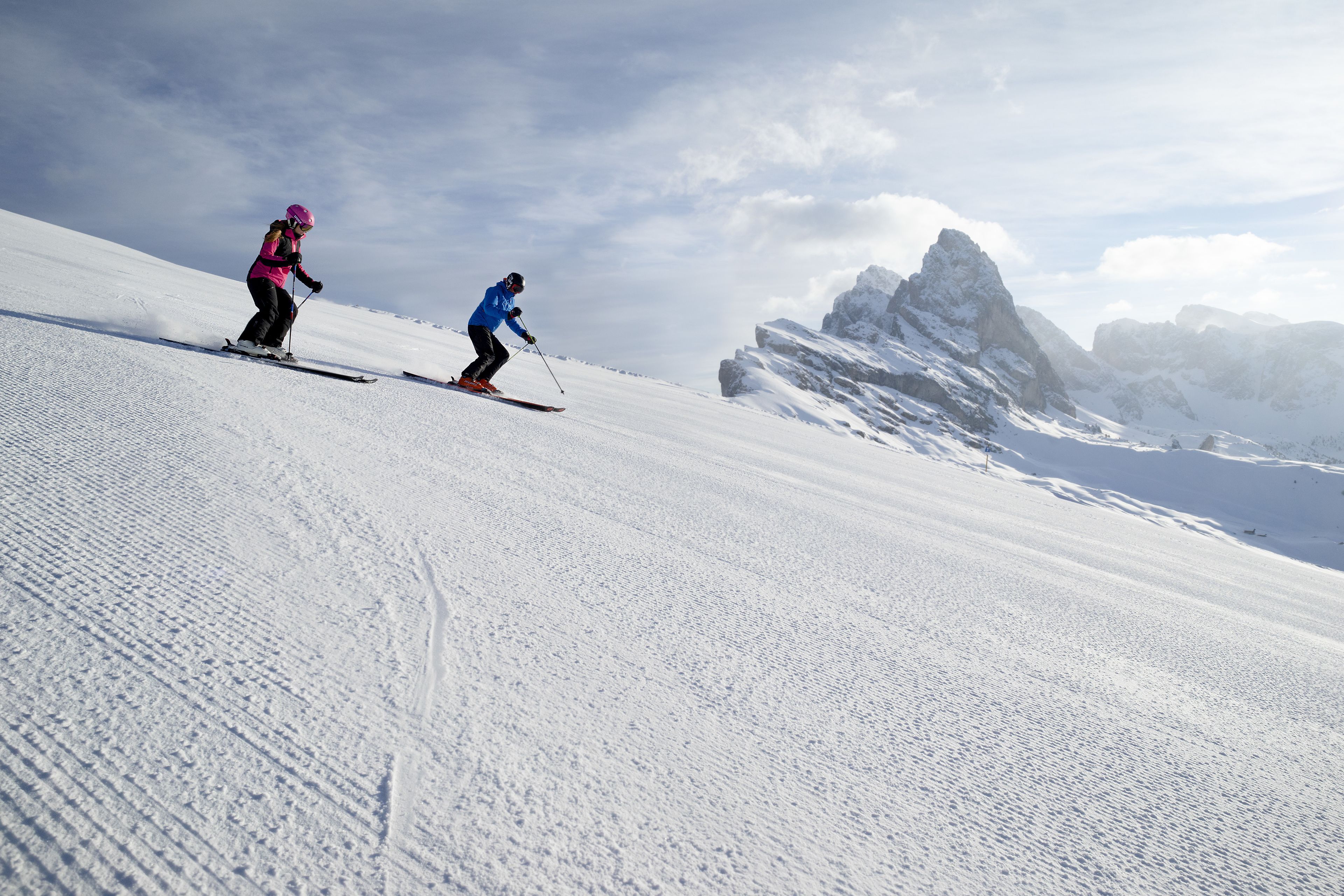 A snowy mountain slope with skiers.