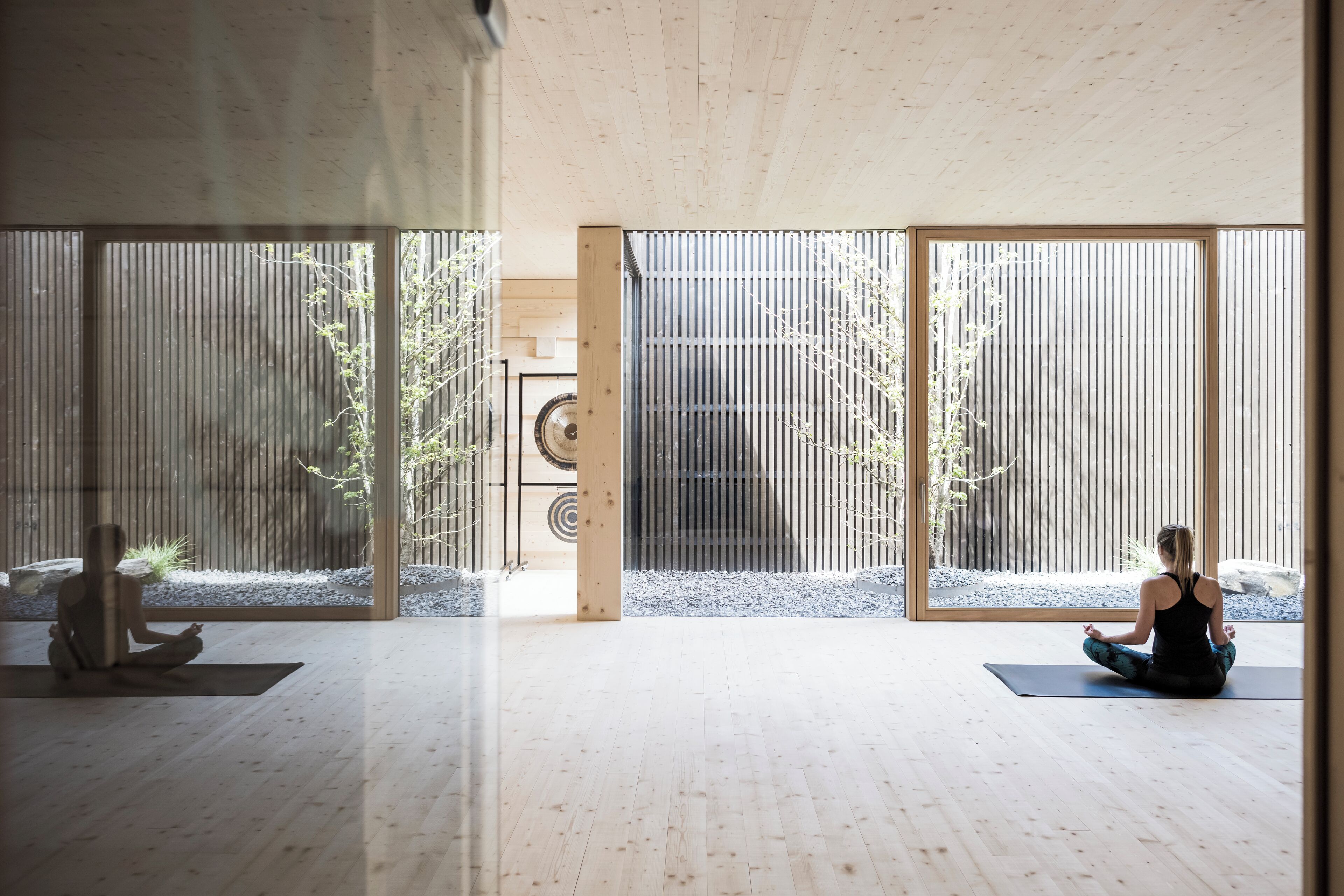 Habitación amplia con suelo de madera y ventanas grandes que dejan entrar abundante luz natural.