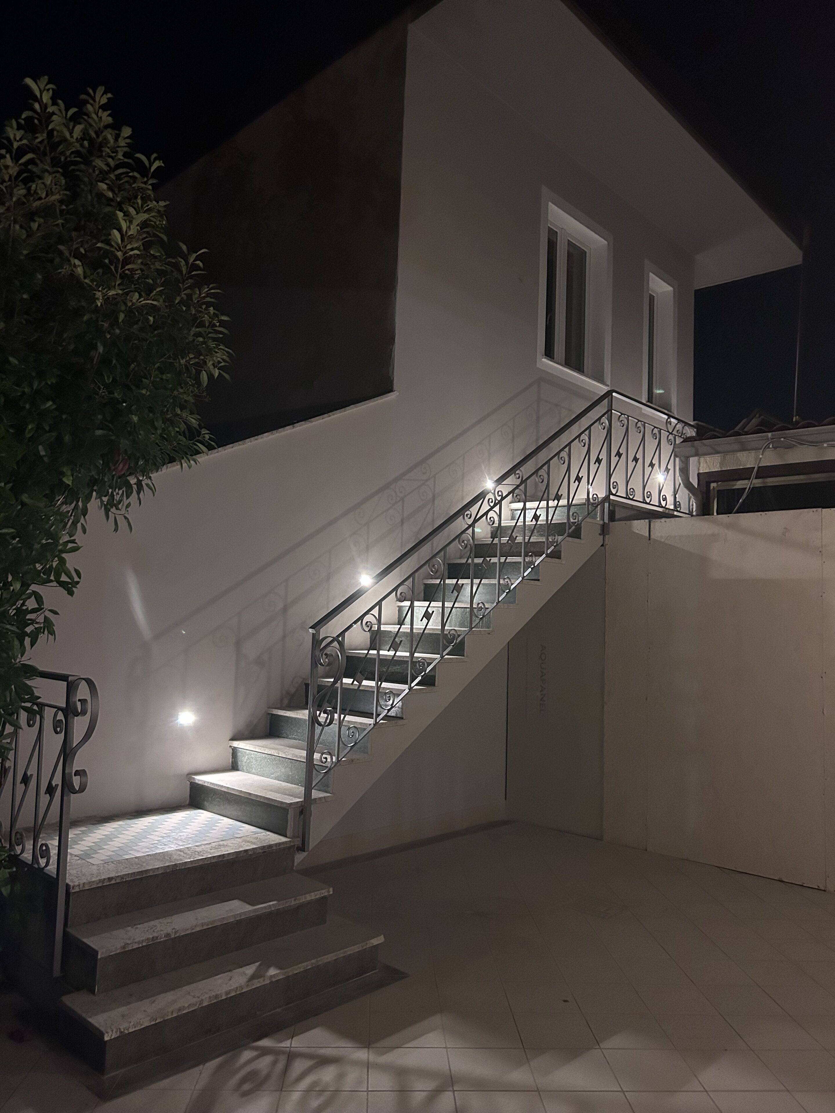 Una escalera con barandales de metal que lleva a un nivel superior.