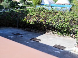 Ein Parkplatz mit markierten Stellplätzen und einem Abflussgitter.