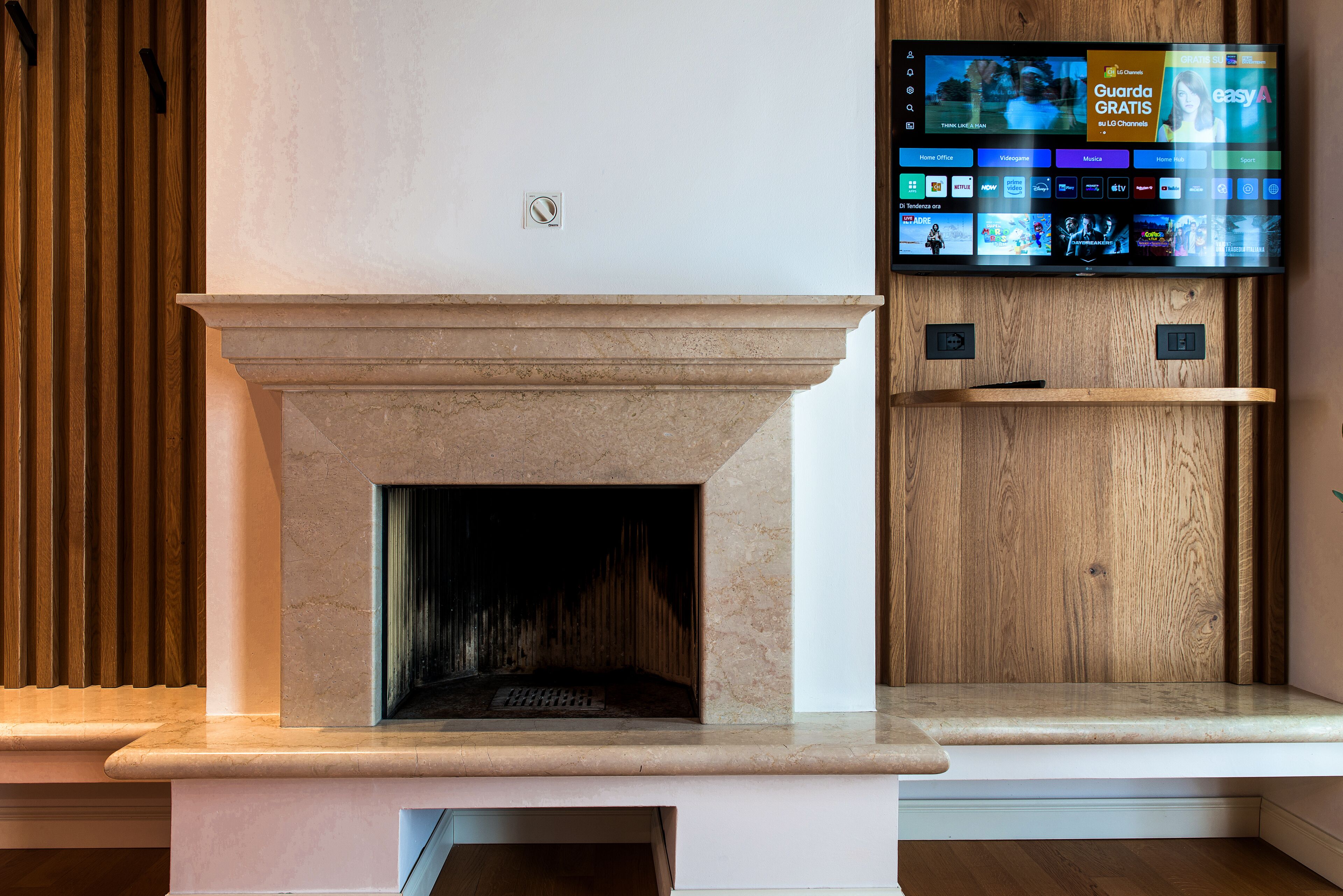 Una chimenea moderna con un televisor montado encima que muestra diferentes servicios de transmisión.