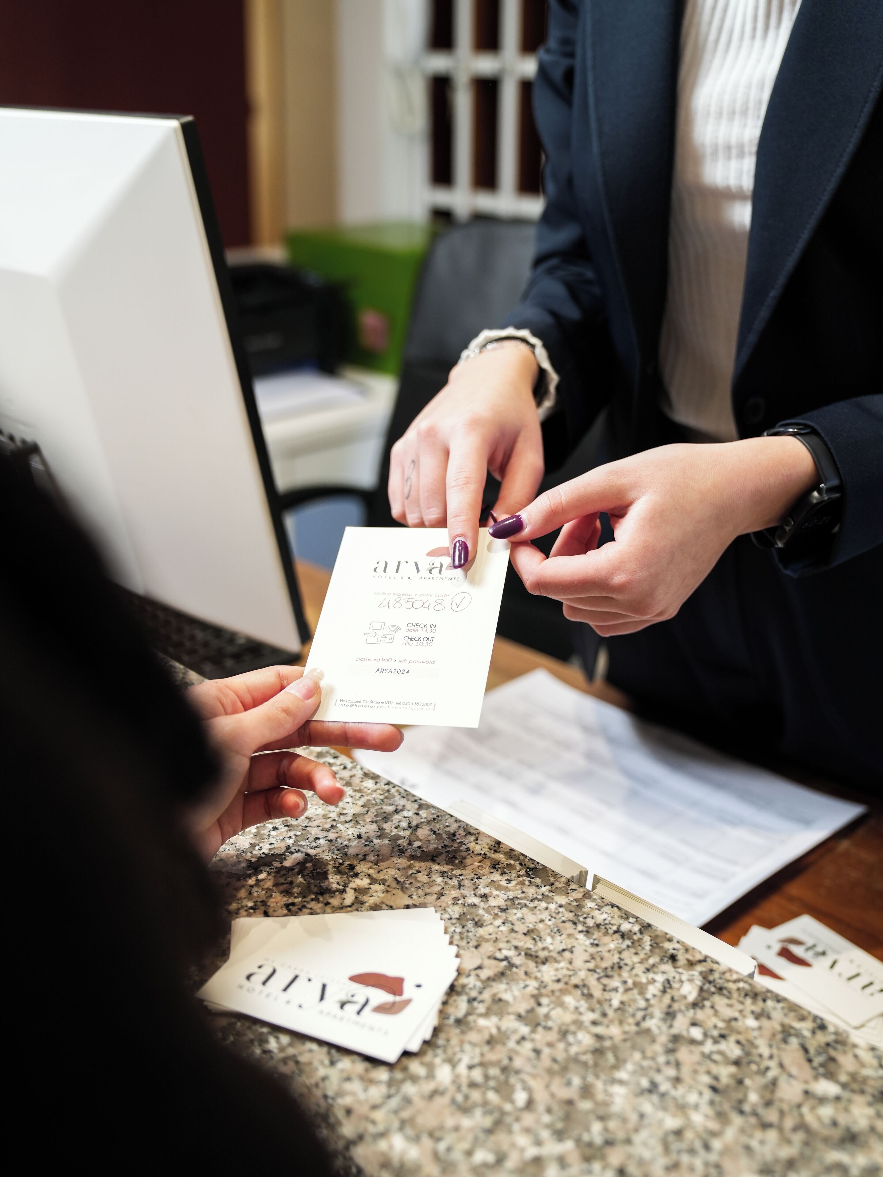 Een persoon die een kaart vasthoudt met de tekst 'arya' en 'hotel', wat duidt op een hoteltransactie.