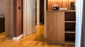 Uma área de recepção de hotel com um balcão de madeira, uma máquina de café e um dispensador de água.
