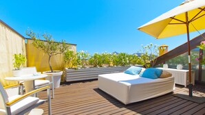 A rooftop terrace with a bed, seating area, and potted plants. - Cas Ferrer Nou Hotelet (Alcúdia)