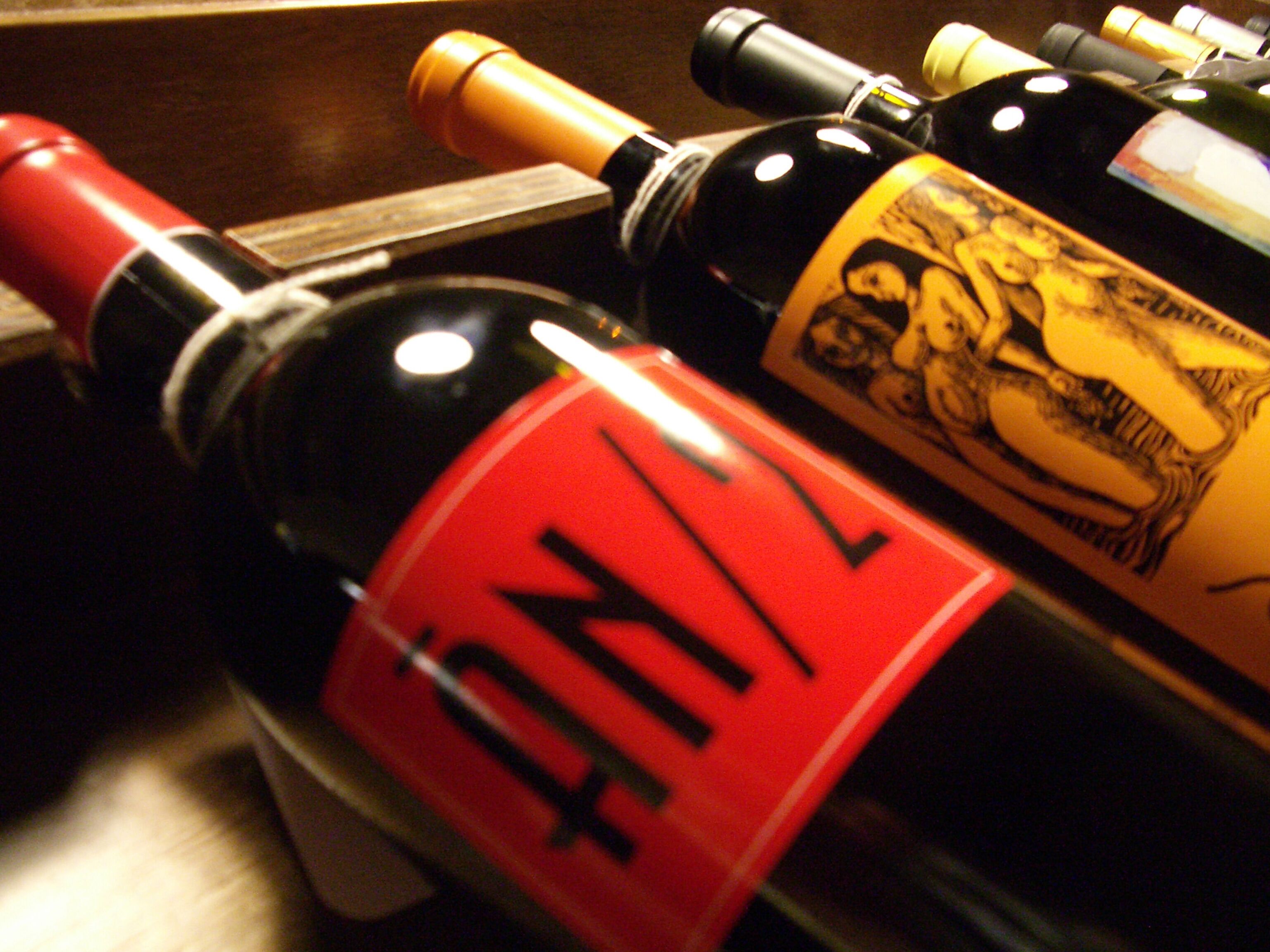 Un conjunto de botellas de vino con etiquetas, algunas con ilustraciones y texto.