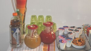A table with various items including a decorative bird, a candle, and several containers of food and drinks. - Marinetta Bed & Breakfast (Signa)