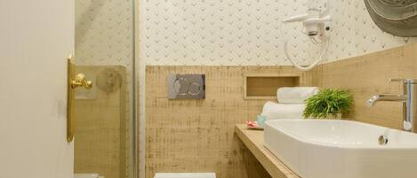 A modern bathroom with a glass shower enclosure, a white toilet, a wooden vanity with a sink, and a large mirror.