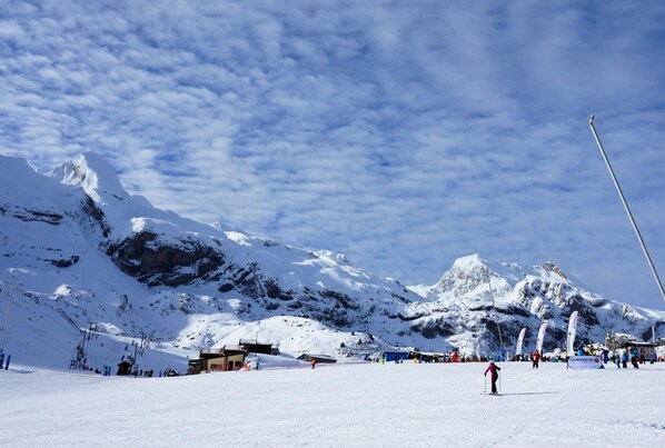 A snowy mountain landscape with a ski resort, including ski lifts and buildings. - Hotel Tobazo (Aisa)
