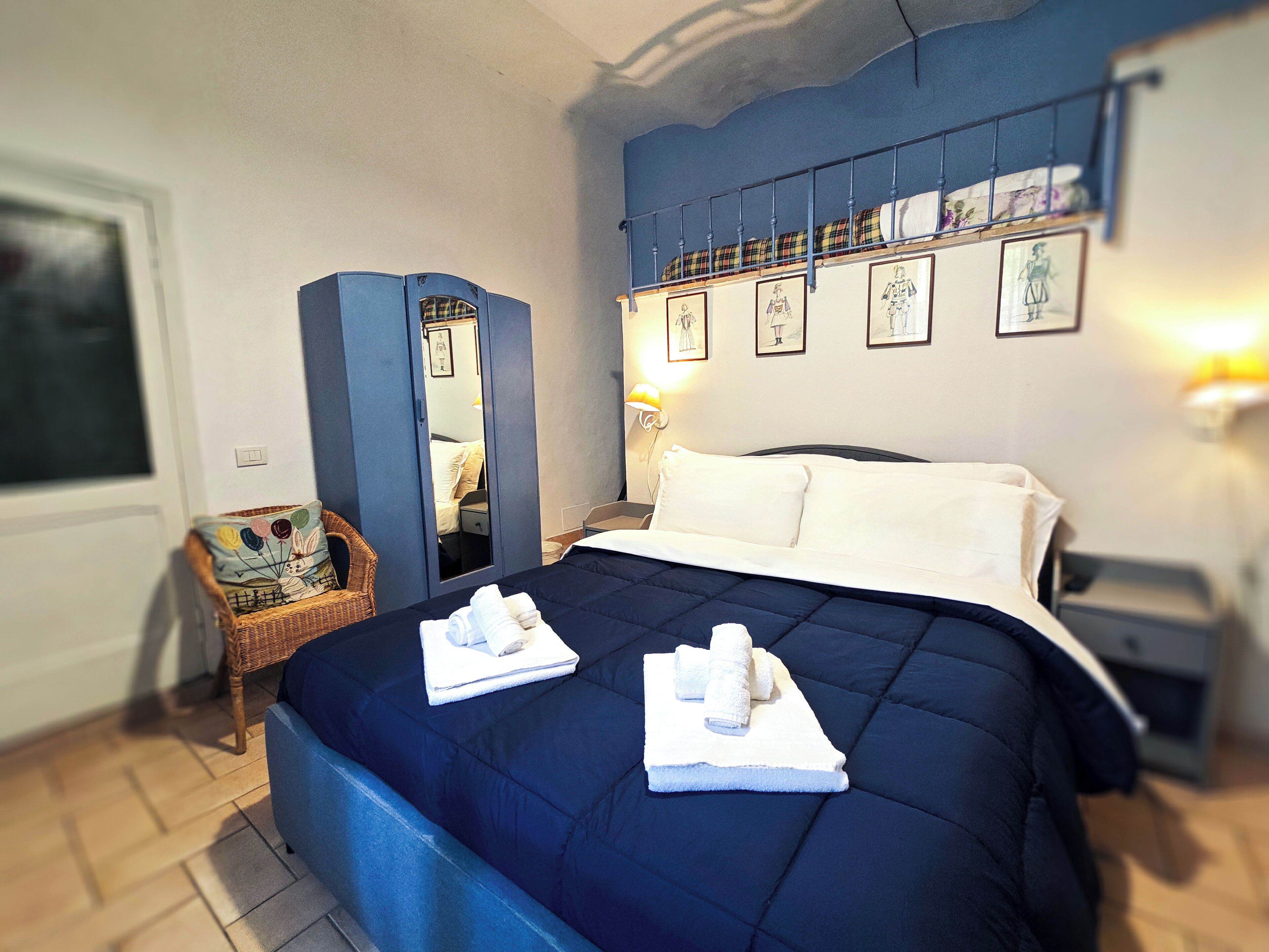 A bedroom with a bed, a dresser, a mirror, and a chair.