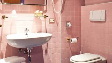 Un baño con lavabo, inodoro, bidé y espejo.
