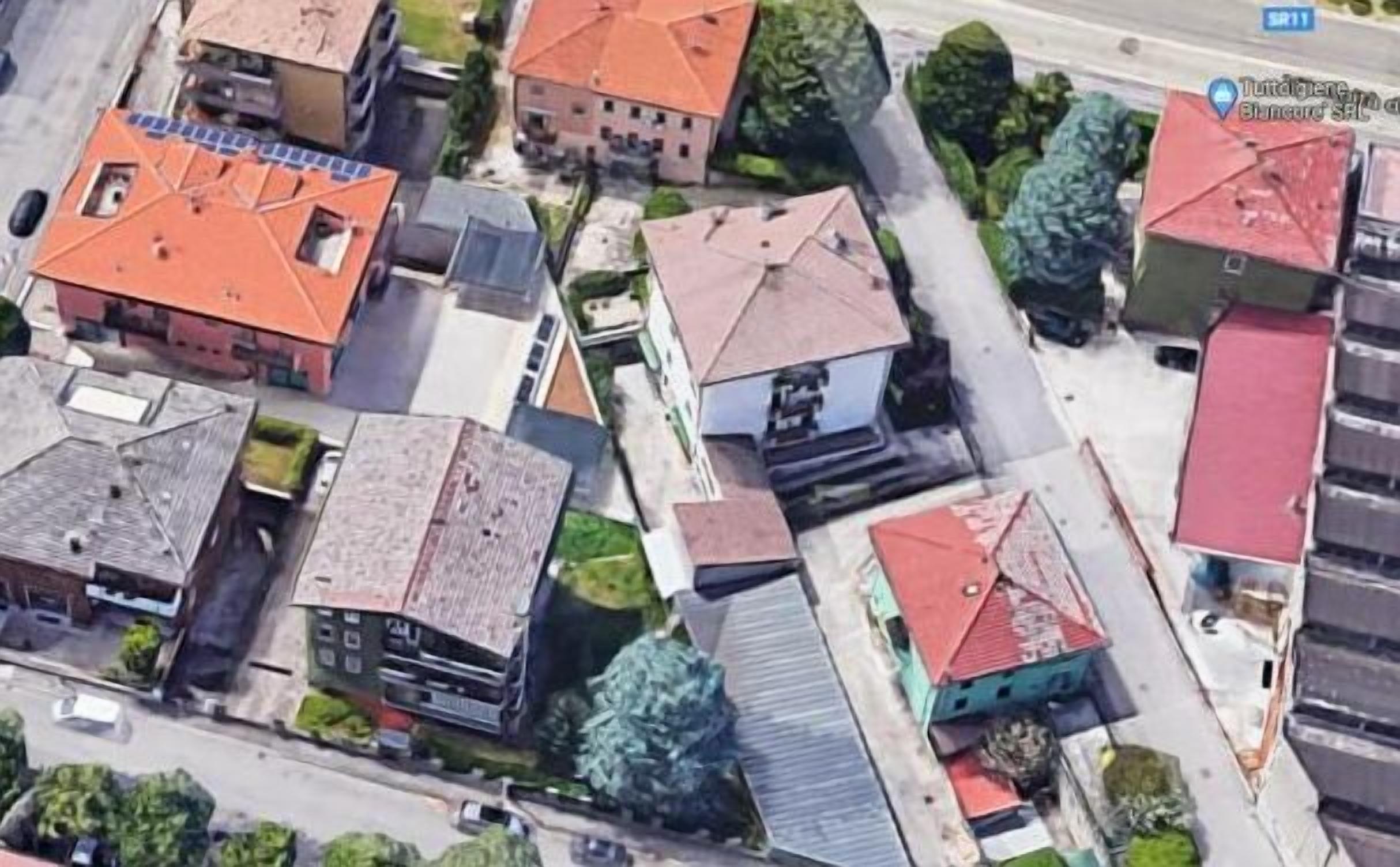 Vista aérea de uma área residencial com várias casas, cada uma com cores e estilos arquitetônicos diferentes.