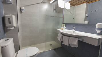 Une salle de bain moderne avec une douche à parois de verre, des toilettes, un lavabo avec un porte-serviettes et un miroir.