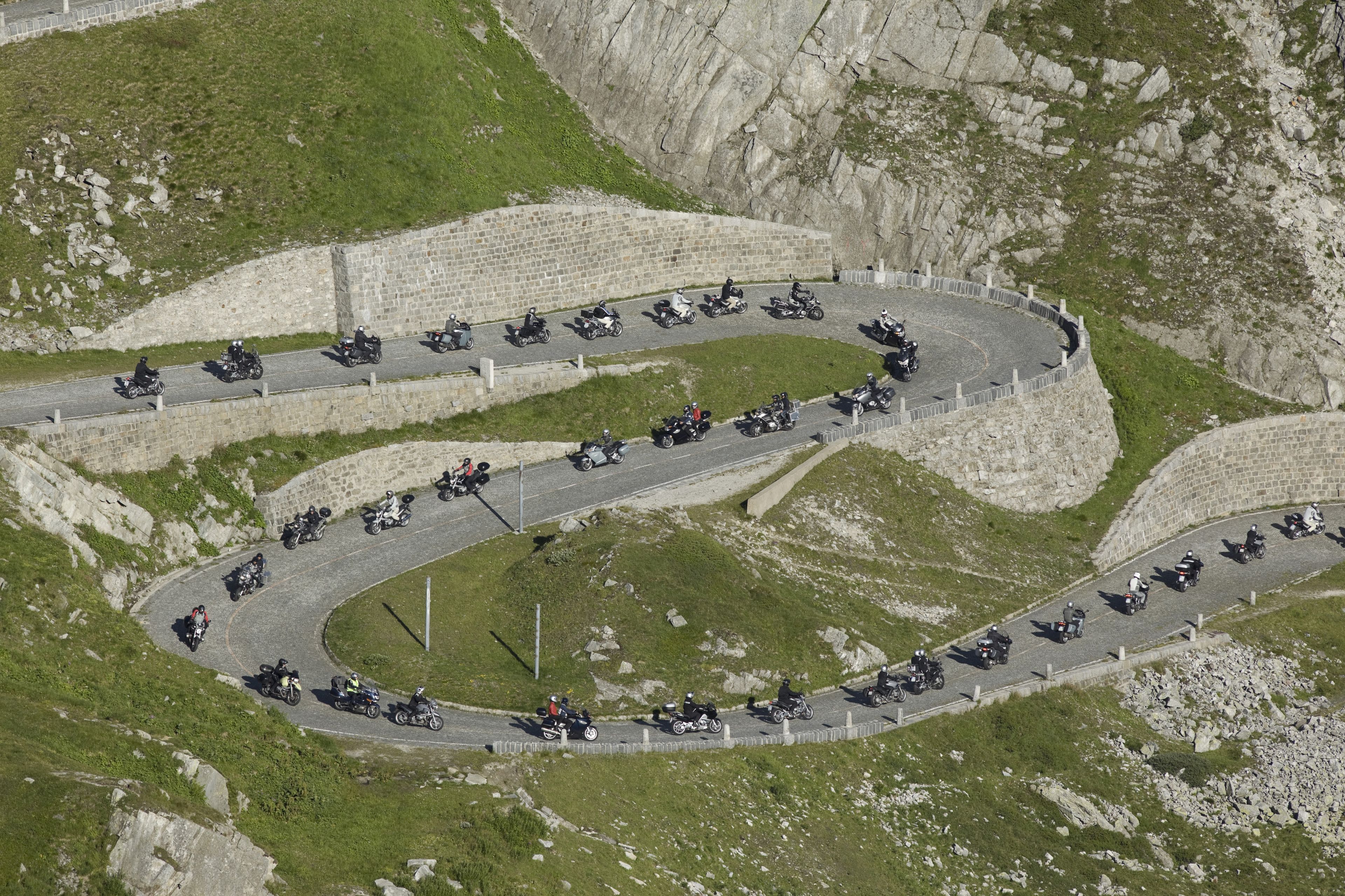 Una strada di montagna tortuosa con diversi motociclisti.