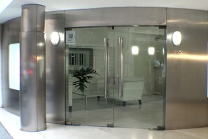 A modern elevator with a glass door, a potted plant, and a visible floor number 1465. - Art Suites (Buenos Aires)