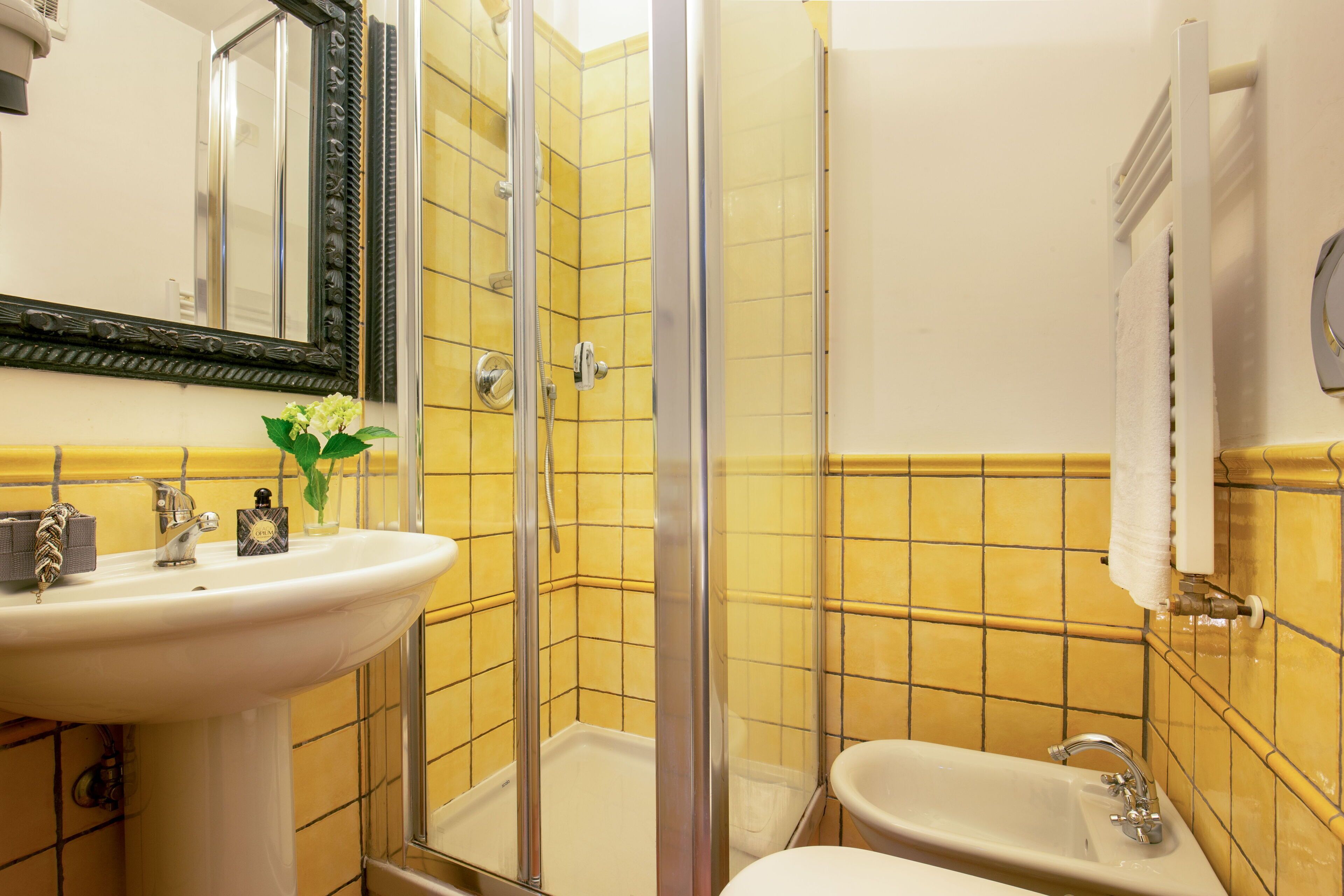 A bathroom with a sink, mirror, shower, and toilet.