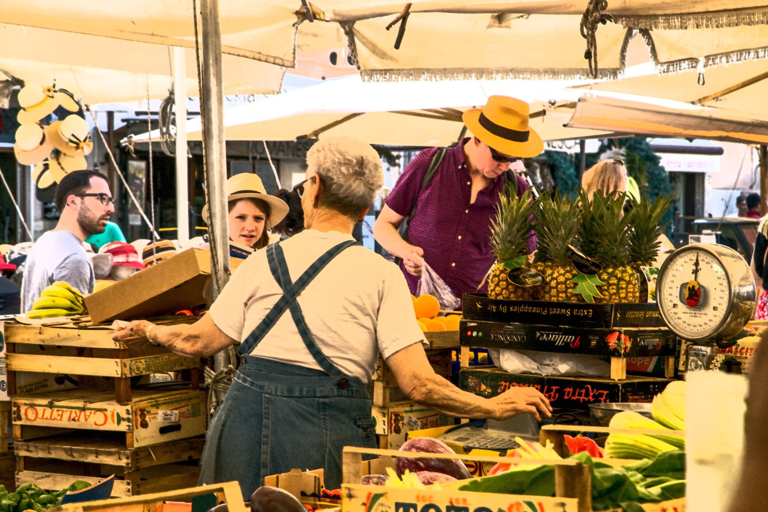 A market stall with various fruits and vegetables, including bananas and pineapples.
