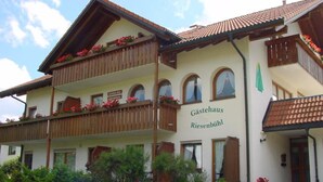 A traditional two-story building with a sign reading "Gästehaus Riesenbühl".