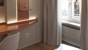 A hotel room with a built-in shelf, a window with curtains, and a view of the cityscape. - Relais Balcone di Giulietta (Verona)