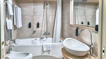 A modern bathroom with a bathtub, a freestanding sink, and a shower area.