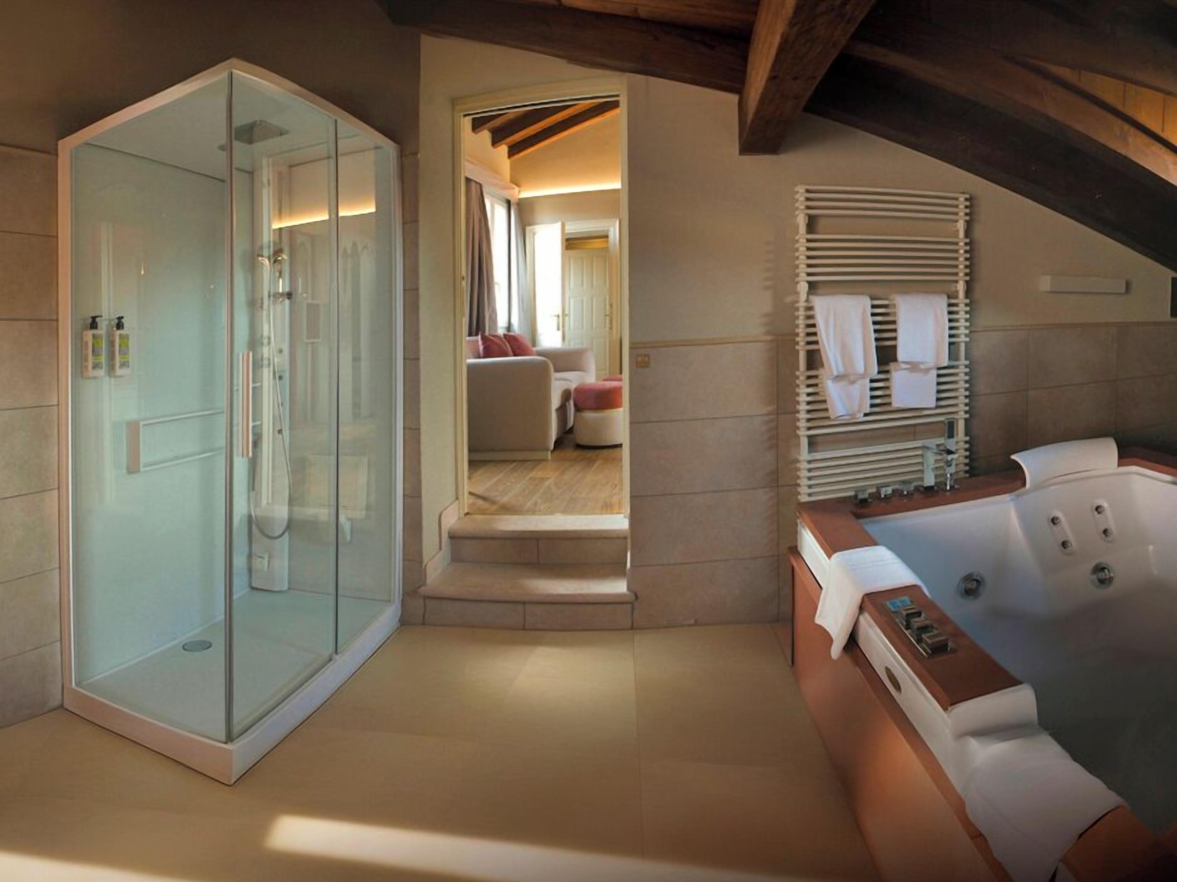 Superior studio suite | Badkamer | Een bad/douchecombinatie, een bubbelbad, een regendouche