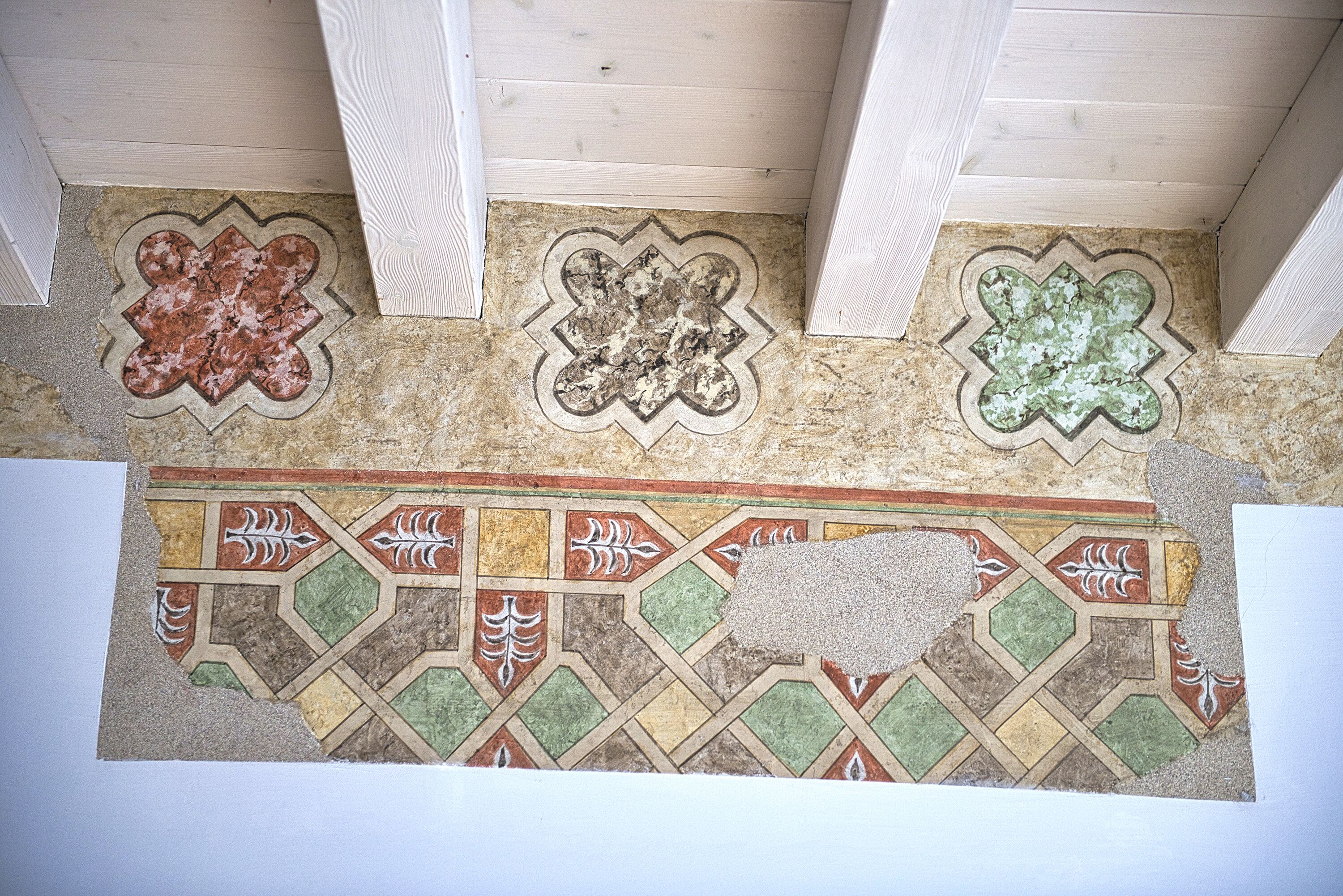 A mosaic floor with geometric patterns and a central rectangular area with a hole.