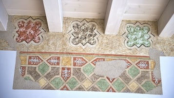A mosaic floor with geometric patterns and a central rectangular area with a hole.