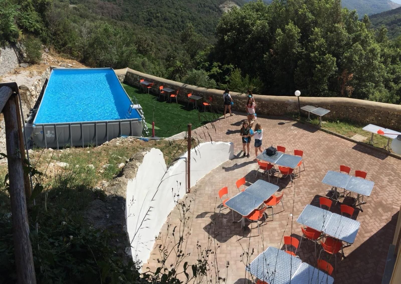 Una piscina al aire libre de temporada, sombrillas