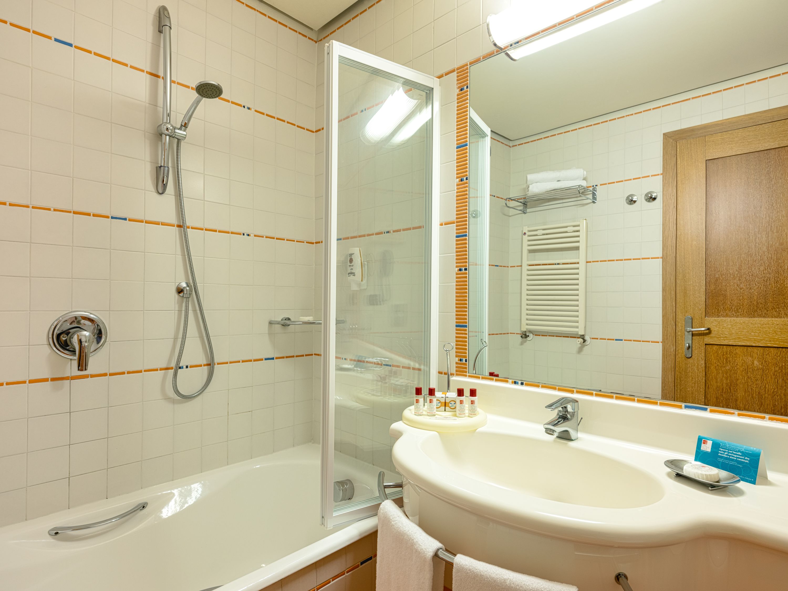 A bathroom with a shower, a sink, and a mirror.