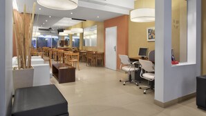 A modern interior with a reception desk, seating area, and a computer station. - Milan Hotel (Buenos Aires)