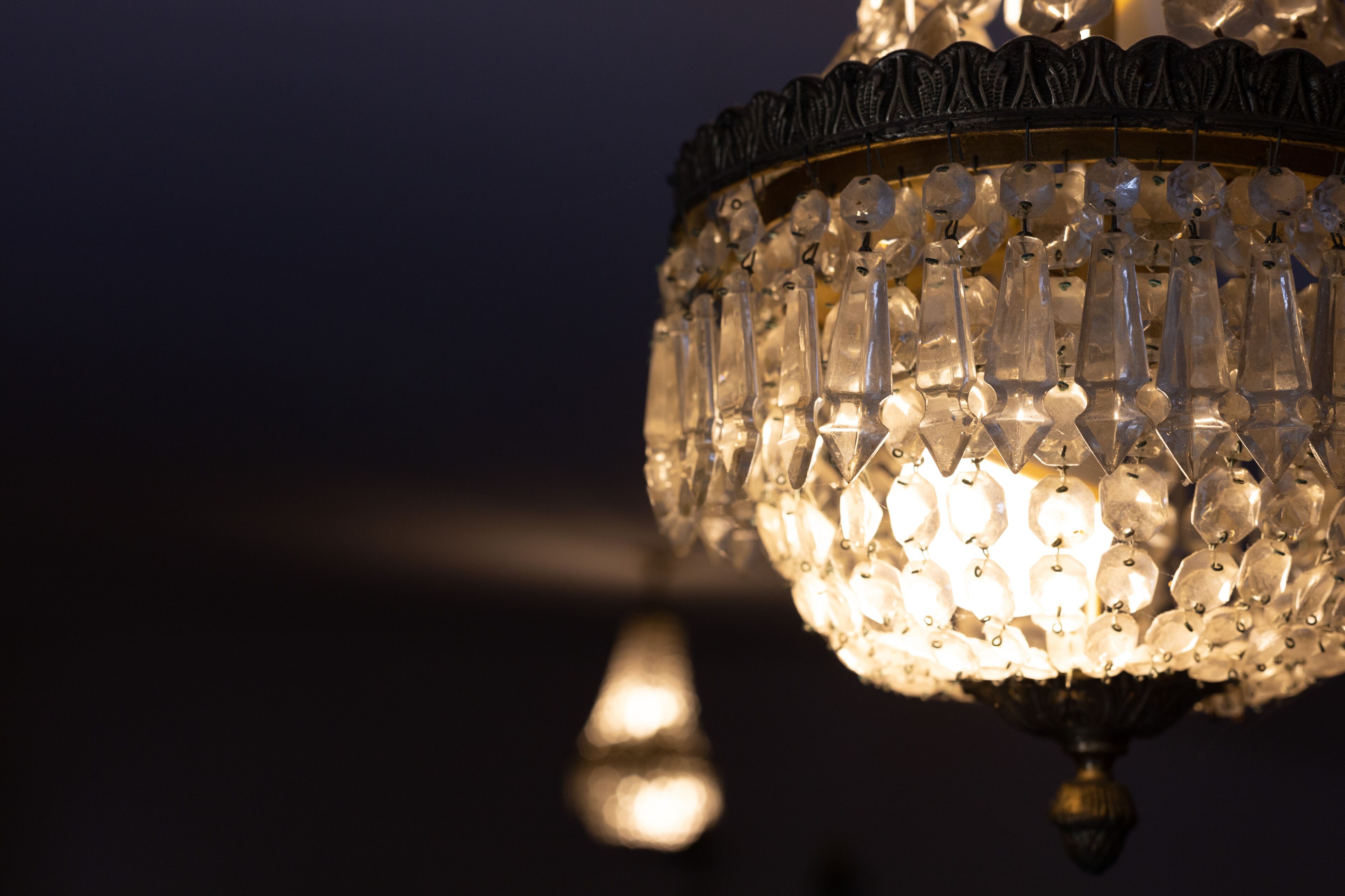 Un candelabro con múltiples detalles de cristal sobre un fondo oscuro.