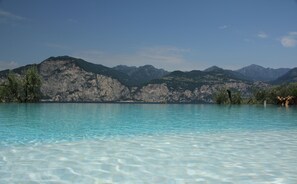 Una piscina cristalina con una montaña de fondo.