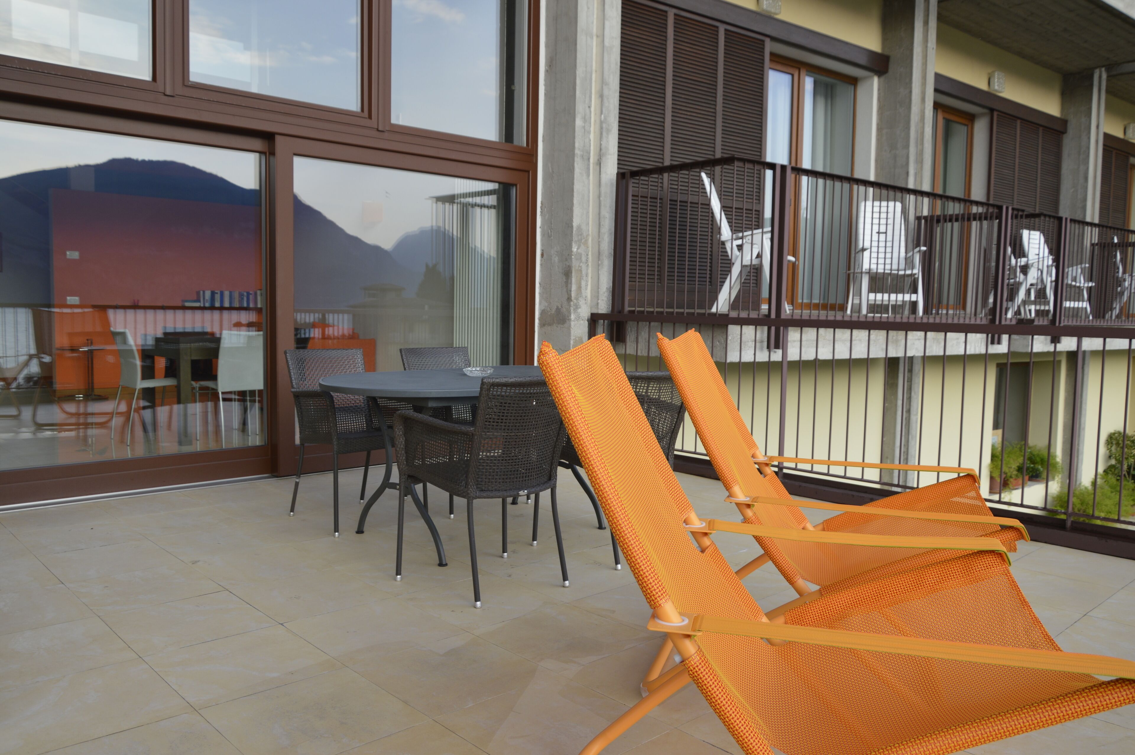 A balcony with outdoor furniture, including chairs and a table.