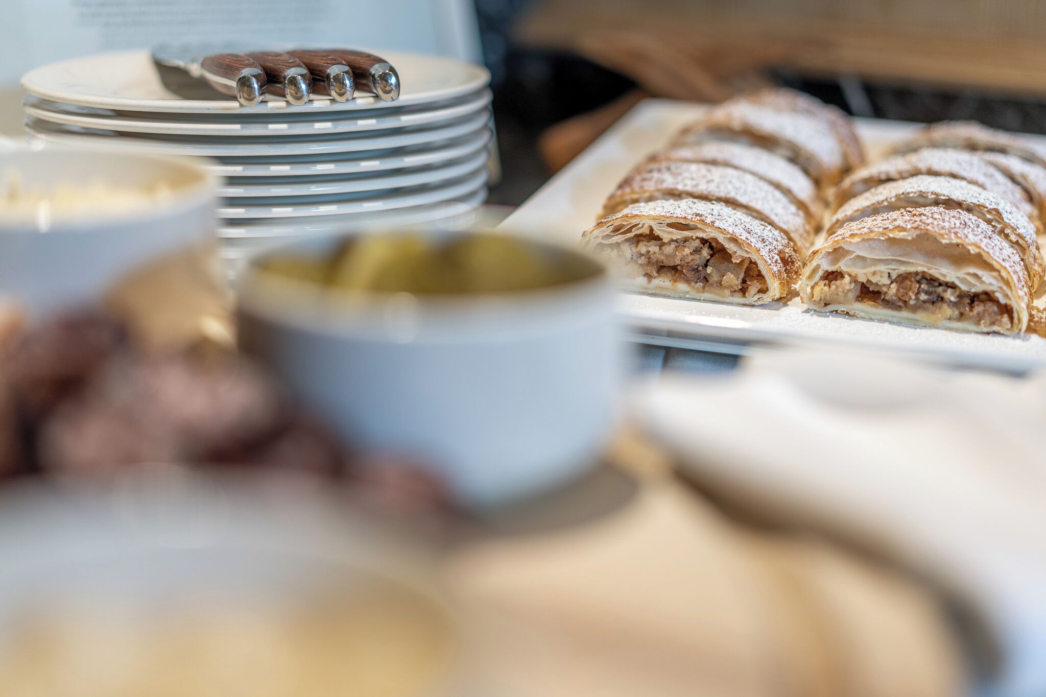 A table with plates, a bowl, and a pastry dish.