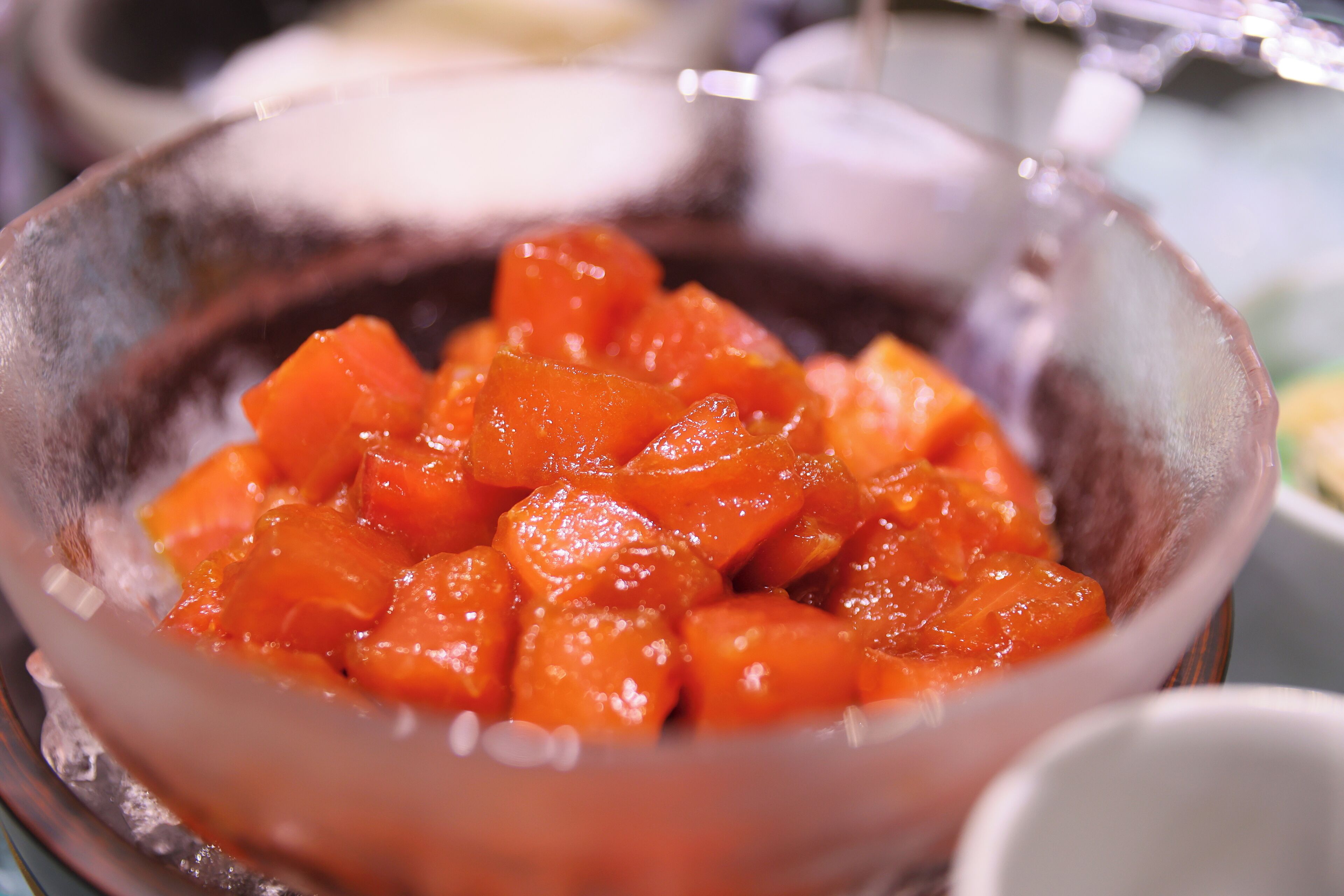 A bowl of diced orange fruit, possibly mango, in a clear glass bowl.