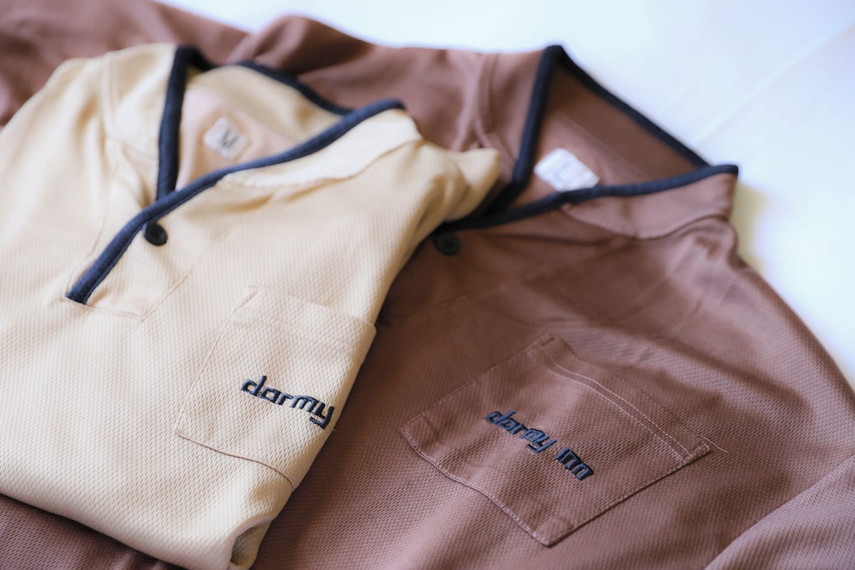 Two bags with "darmy" embroidered on them, placed on a surface.