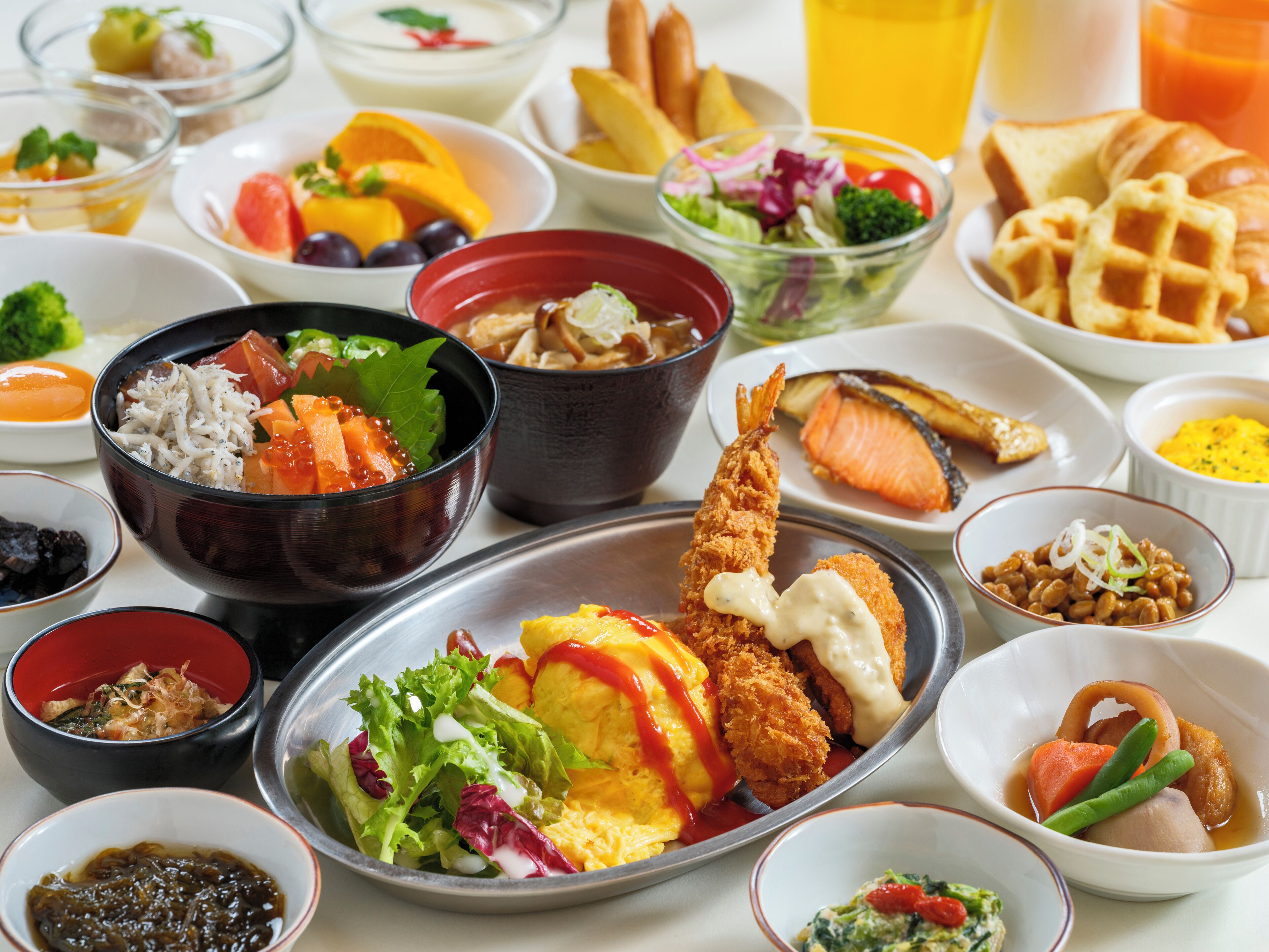 A variety of dishes including sushi, salad, and bread.