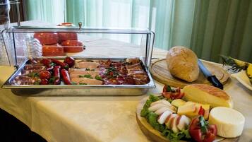 Buffet com diversos alimentos, incluindo carnes, queijos e vegetais.
