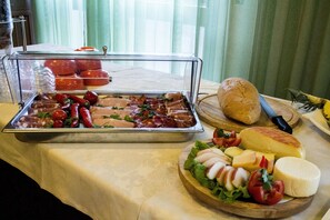 A buffet with various food items including meats, cheeses, and vegetables.