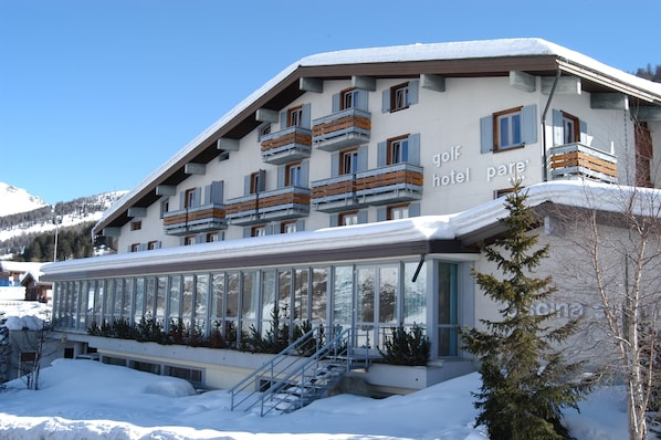 A ski resort hotel with multiple balconies and a glass facade.