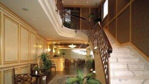 A grand staircase with marble steps leading to a dining area. - Hotel De la Ville (Saint-Vincent)